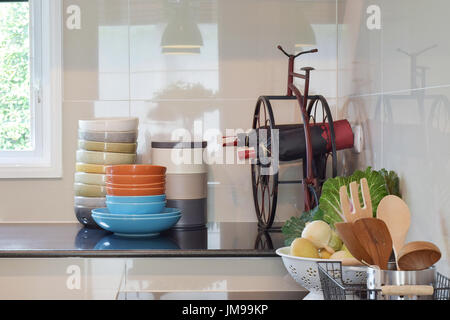 Assiettes et bols colorés et des bouteilles de vin de granit noir sur la page dans la cuisine Banque D'Images