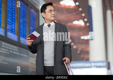 Homme d'affaires chinois avec passeport et billet d'avion Banque D'Images