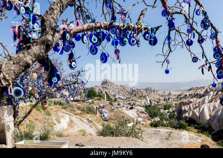 Mauvais Œil des perles sur arbre et cheminées de fées sur fond de ciel bleu dans la vallée de Guvercinlik, Goreme,Turquie.Branches du vieil arbre décoré de t Banque D'Images