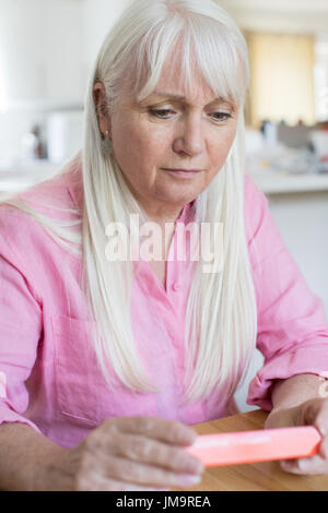 Senior Woman Reading de l'information sur l'emballage des médicaments Banque D'Images