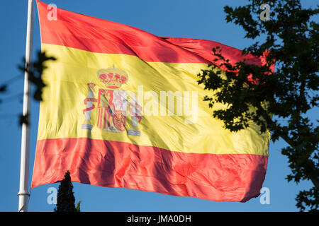 Grand drapeau espagnol dans la brise soufflant sur une place de Madrid, Espagne Banque D'Images