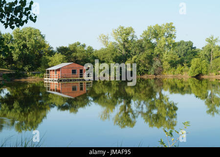 Une cabane à pêche rouge sur un lac calme Wichita Kansas USA Banque D'Images