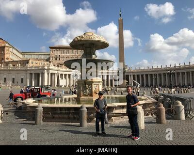 Vatican arrête l'eau des fontaines anciennes à Saint Peters Square, Rome, Italie, 25 août 2017. Mon mari et son fils en face de l'eau calme. Le temps était extrêmement chaud et les touristes ont été constamment courir à l'eau gratuite dans certaines fontaines afin d'étancher leur soif. J'étais l'un d'entre eux. La plupart des fontaines arrêté, mais un peu petite pour la boisson était autorisée, et nous avons tous beaucoup apprécié puisqu'il a été frappant 90-92F depuis quelques jours. Banque D'Images
