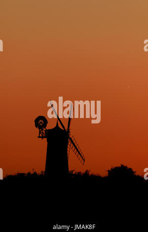 Great Bircham, UK. Le 25 juillet, 2017. Le ciel est devenu orange, silhouetting Bircham windmill in Norfolk juste après le coucher du soleil. Bircham Mill a été construit en 1846, mais dans les années 20, les voiles ont été supprimés et la tour a été abandonné, mais maintenant c'est un moulin entièrement restauré et de travail Bircham windmill in Great Bircham, Norfolk le 25 juillet 2017 Crédit : Paul Marriott/Alamy Live News Banque D'Images