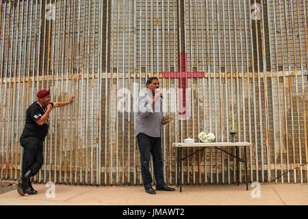 Tijuana, Baja California, Mexique. 25 Juin, 2017. HECTOR VARELA-Barajas (à gauche), un vétéran de l'armée américaine, et le pasteur GUILLERMO NAVARRETE (droite) assister à un bi-national hebdomadaire de la communion à l'Église Frontière El Faro à Tijuana, Baja California, Mexique. Le service est tenu simultanément des deux côtés de la frontière chaque dimanche la mise en commun des ressources à Tijuana et San Diego. Crédit : Joel Angel Juarez/ZUMA/Alamy Fil Live News Banque D'Images