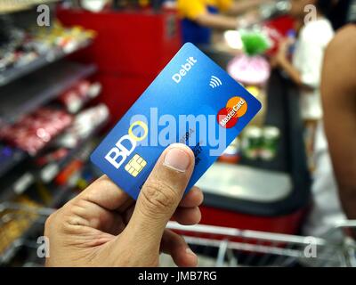 ANTIPOLO CITY, PHILIPPINES - le 17 juillet 2017 : un client utilise une carte de débit de BDO pour payer des articles d'épicerie. Banque D'Images