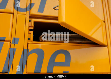 Porte à un jaune vif Amazon Locker appelé Binky ouvert après l'entrée de code de collecte permettant l'accès à la parcelle Banque D'Images