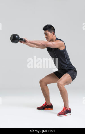 Jeune homme chinois avec kettlebell formation Banque D'Images