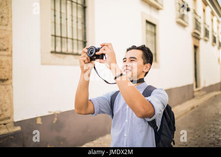 Hobby et jeune homme voyage avec sac à dos en tenant avec sa caméra sur la rue de l'Asie Banque D'Images