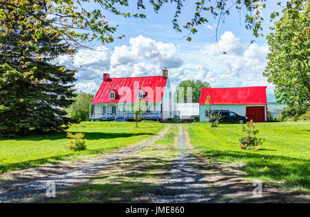 L'ÎLE D'Orléans, Canada - 1 juin 2017 : maison toit peint en rouge avec la campagne française paysage en été Banque D'Images