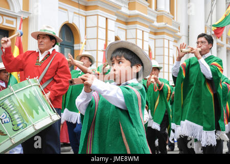 Un petit garçon bolivien en costumes traditionnels jouant la flûte durant la célébration de la journée de la fondation de l'État plurinational, La Paz, Bolivie Banque D'Images