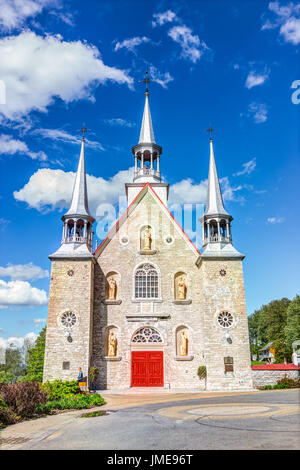 L'ÎLE D'Orléans, Canada - juin 1, 2017 : l'église de Sainte-Famille peint rouge avec l'architecture en pierre et ciel bleu en été Banque D'Images