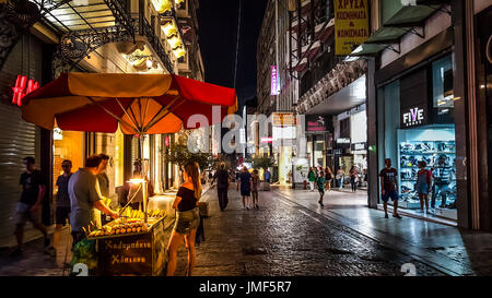 La fin de nuit dans le quartier de Monastiraki Athènes Grèce sur un soir de pluie tandis qu'un jeune femme attend pour sa commande d'un panier alimentaire vendeur Banque D'Images