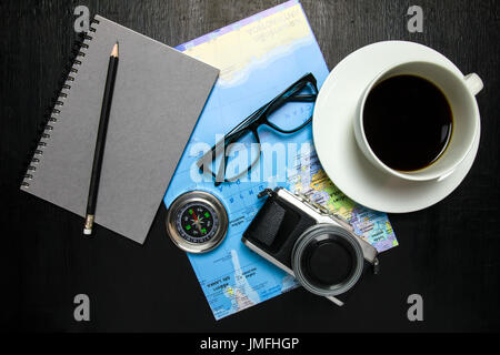 Vue de dessus de l'espace de travail de bureau avec une tasse à café, appareil photo, boussole, carte du monde,ordinateur portable,lunettes ,crayon sur fond de bois Banque D'Images