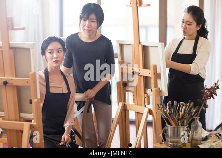 Professeur d'art avec les jeunes femmes en studio Banque D'Images