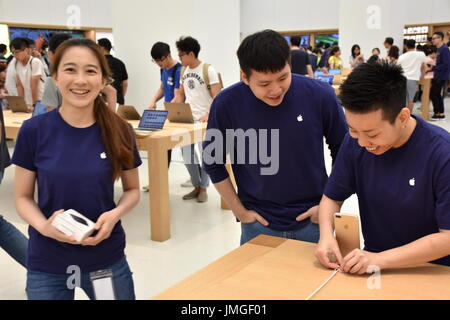 Trois employés Apple gaiement travailler à l'ouverture du 1er siège Apple situé dans Taipei 101, Taipei, Taiwan. Banque D'Images