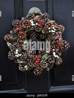 Cône de pin couronne de Noël sur porte avant Banque D'Images