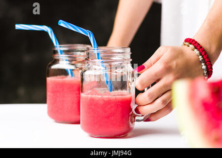 Femme holding fresh watermelon smoothies en pots Banque D'Images