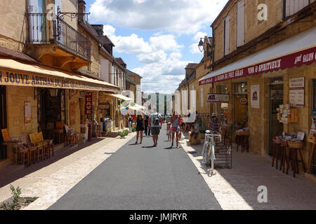 Les touristes marchant dans la rue principale dans le Dordogne village de Domme Banque D'Images