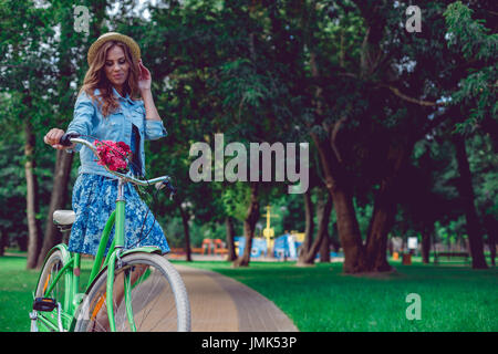 Portrait of smiling young woman sitting in the park. Banque D'Images