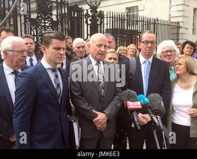 Edward Barnard, dont le frère Patrick a été assassiné par le gang Glenanne, entouré d'avocats et d'autres parents qui ont perdu des êtres chers à mains de gang, parler aux médias en dehors de Belfast après qu'un juge de la Haute Cour a conclu que la police n'a pas mener un examen global d'état avec la complicité de la célèbre piste de meurtre loyalistes en Irlande du Nord était incompatible avec ses obligations en matière de droits humains. Banque D'Images