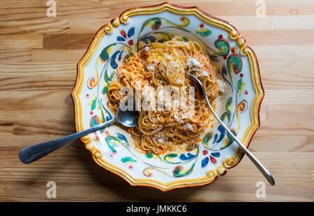 Spaghettini, ou pâtes fines, avec tomate, oignon, beurre et fromage Parmigiano-Reggiano (parmesan). Banque D'Images
