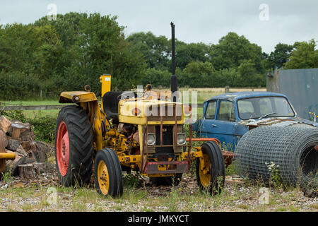 Ancienne, la rouille jaune, le tracteur sur la masse des déchets. Banque D'Images