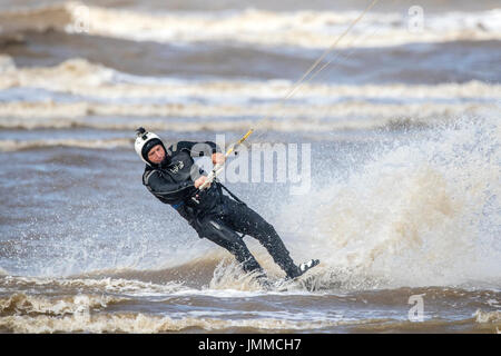 Southport, Merseyside, 28 juillet 2017. Météo britannique. Résident local 'John Rimmer' rides les vagues avec la marée montante comme il le kite surf sur la plage de Southport Merseyside. Avec des périodes de soleil magnifiques devrait se poursuivre tout au long de la journée, une belle journée est prévue au cours de la populaire station balnéaire. Credit : Cernan Elias/Alamy Live News Banque D'Images