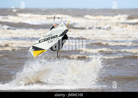 Southport, Merseyside, 28 juillet 2017. Météo britannique. Résident local 'John Rimmer' rides les vagues avec la marée montante comme il le kite surf sur la plage de Southport Merseyside. Avec des périodes de soleil magnifiques devrait se poursuivre tout au long de la journée, une belle journée est prévue au cours de la populaire station balnéaire. Credit : Cernan Elias/Alamy Live News Banque D'Images