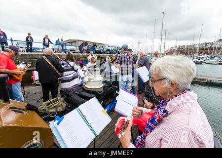 Concert par l'accord groupe, The Sunshine Ukes sur le dos d'un remorqueur, le Cervia, ancrés dans le port au cours de la fête de Ramsgate. Principalement des aînés, hommes et femmes, assis sur le pont arrière du bateau. Banque D'Images