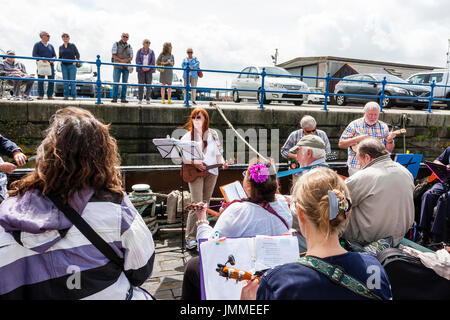 Concert par l'accord groupe, The Sunshine Ukes sur le dos d'un remorqueur, le Cervia, ancrés dans le port au cours de la fête de Ramsgate. Principalement des aînés, hommes et femmes, assis sur le pont arrière du bateau. Banque D'Images