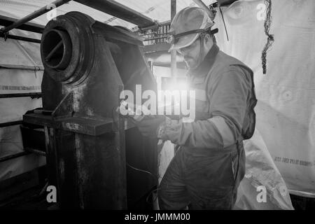 Image en noir et blanc, d'un inspecteur ndt, contrôle de l'épaisseur de soudure, sur une mer du Nord Industrie pétrolière et gazière forage. crédit : lee ramsden / alamy Banque D'Images