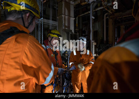 Accès sur corde superviseur, ( 3 ) niveau irata discuter de la boîte à outils parler à son équipe, sur la mer du Nord une plate-forme de pétrole et de gaz. crédit : lee ramsden / alamy Banque D'Images