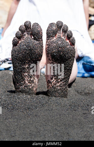 Womans pieds plein de sable à la plage noire près de Lorneville, Nouveau Brunswick, canada atlantique sur la baie de fundy Banque D'Images