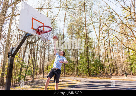 Jeune homme musclé fit sauter lancer en basket-ball hoop Banque D'Images