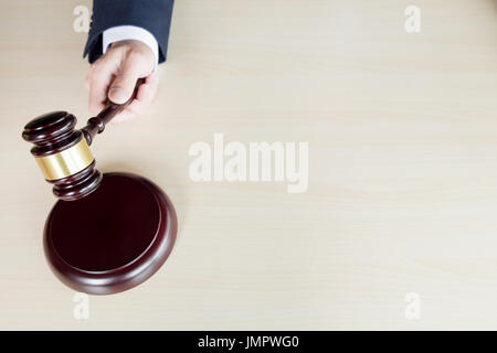 Part du juge de tenir un marteau frappe marteau en bois contre le fond de bois. Banque D'Images