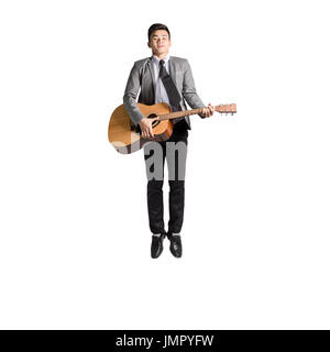 Portrait of a young man jumping avec guitare. Isolé sur fond blanc avec copie espace Banque D'Images