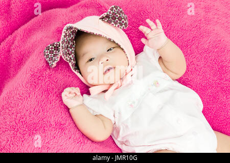 Portrait d'un adorable petit infant baby girl avec head allongé sur le dos sur une couverture rose Banque D'Images