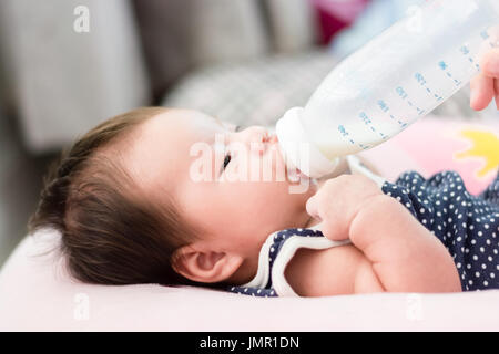 Portrait d'un adorable petit infant baby girl lying on back on breadfeeding oreiller et de l'alimentation Banque D'Images