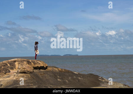 Un homme debout sur un rocher sur l'arrière-plan de salut's islands à Kourou, Guyane Française Banque D'Images