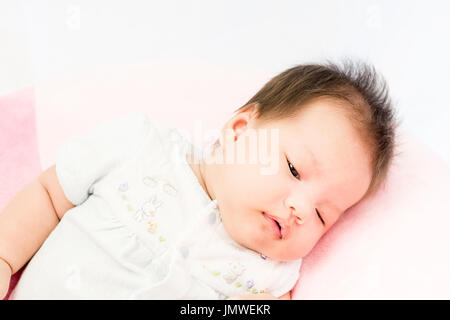 Portrait d'un adorable petit bébé fille bébé allongé sur le dos sur l'oreiller Banque D'Images