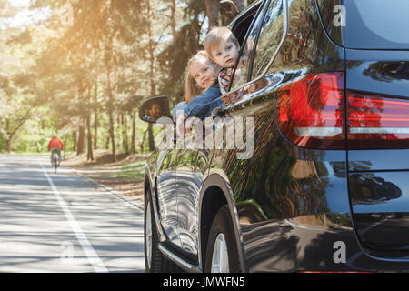 Voyager en voiture rouler ensemble famille frère et soeur se pencher hors de la fenêtre Banque D'Images