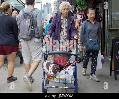 Une vieille femme chinoise à l'extérieur du shopping sur une journée d'été sur Canal Street, à Chinatown, Lower Manhattan, New York City Banque D'Images