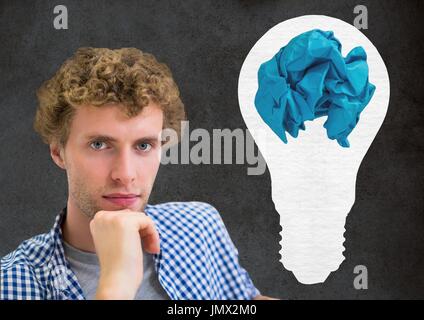 Digital composite de l'Homme debout à côté d'ampoule avec boule de papier froissé in front of blackboard Banque D'Images