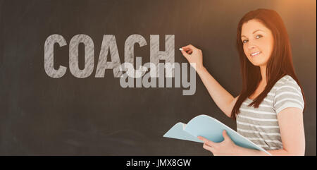 Mot Coach contre jeune femme sur le point d'écrire sur un tableau noir à la recherche de l'appareil photo Banque D'Images