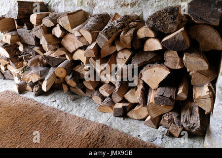 Des piles de grumes se séchant dans le porche d'entrée d'une grande maison de campagne d'Ebglaish Banque D'Images