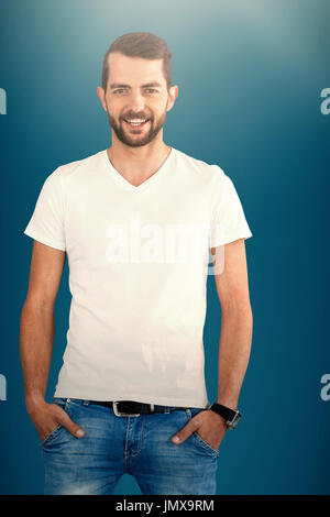 Smiling fashion model avec les mains dans les poches à l'arrière-plan blanc contre fond bleu foncé Banque D'Images