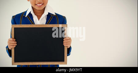 Portrait of businesswoman holding blank slate écrit contre fond blanc Banque D'Images