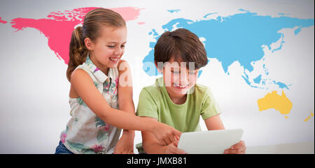 Garçon avec sister using digital tablet contre l'arrière-plan gris Banque D'Images