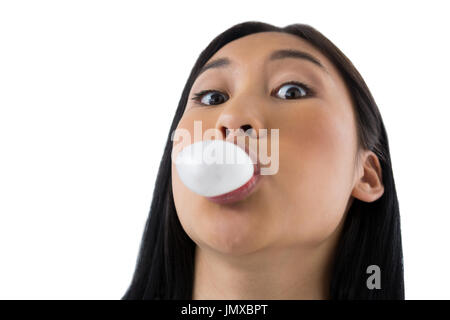 Woman blowing bubble gum against white background Banque D'Images